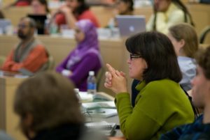 People sit at tables in a classroom