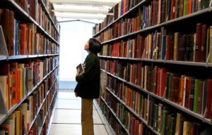 A student looks at bookshelves in a library